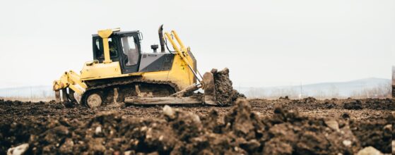 mini industrial bulldozer moving dirt and earth with scoop. Industrial details of landscaping